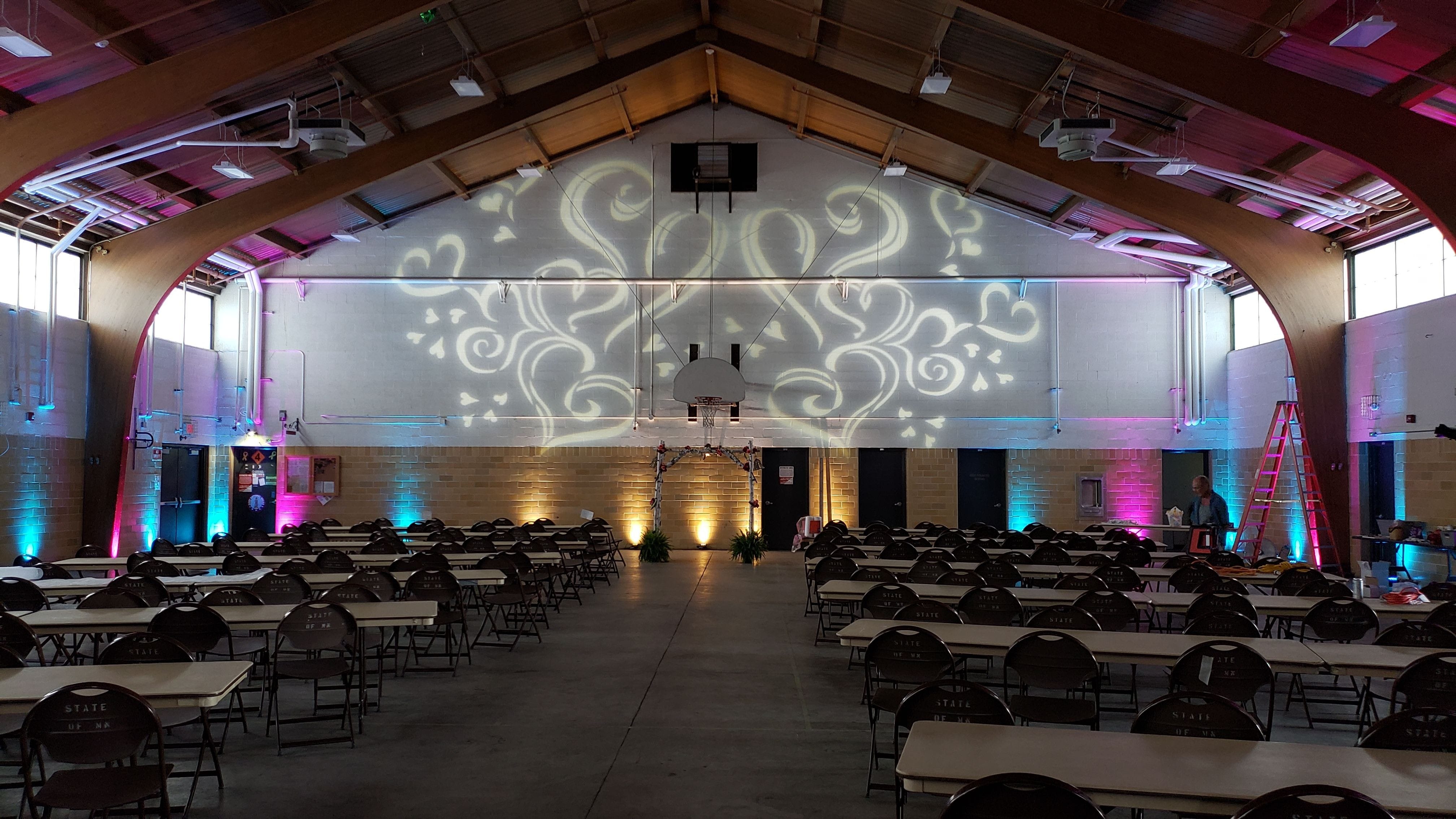 Wedding lighting at the Cloquet Armory by Duluth Event Lighting. Up lighting in blue, teal and magenta with fun heart gobos on the walls.