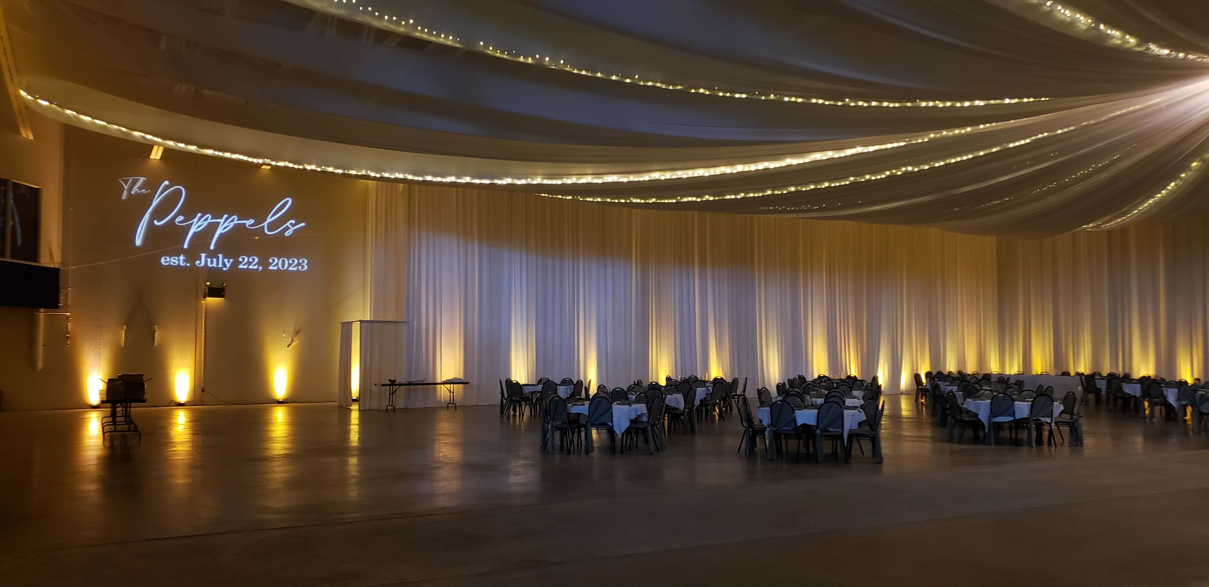 Wedding lighting at the Eveleth Curling Club with soft gold up lighting and a wedding monogram by Duluth Event Lighting.