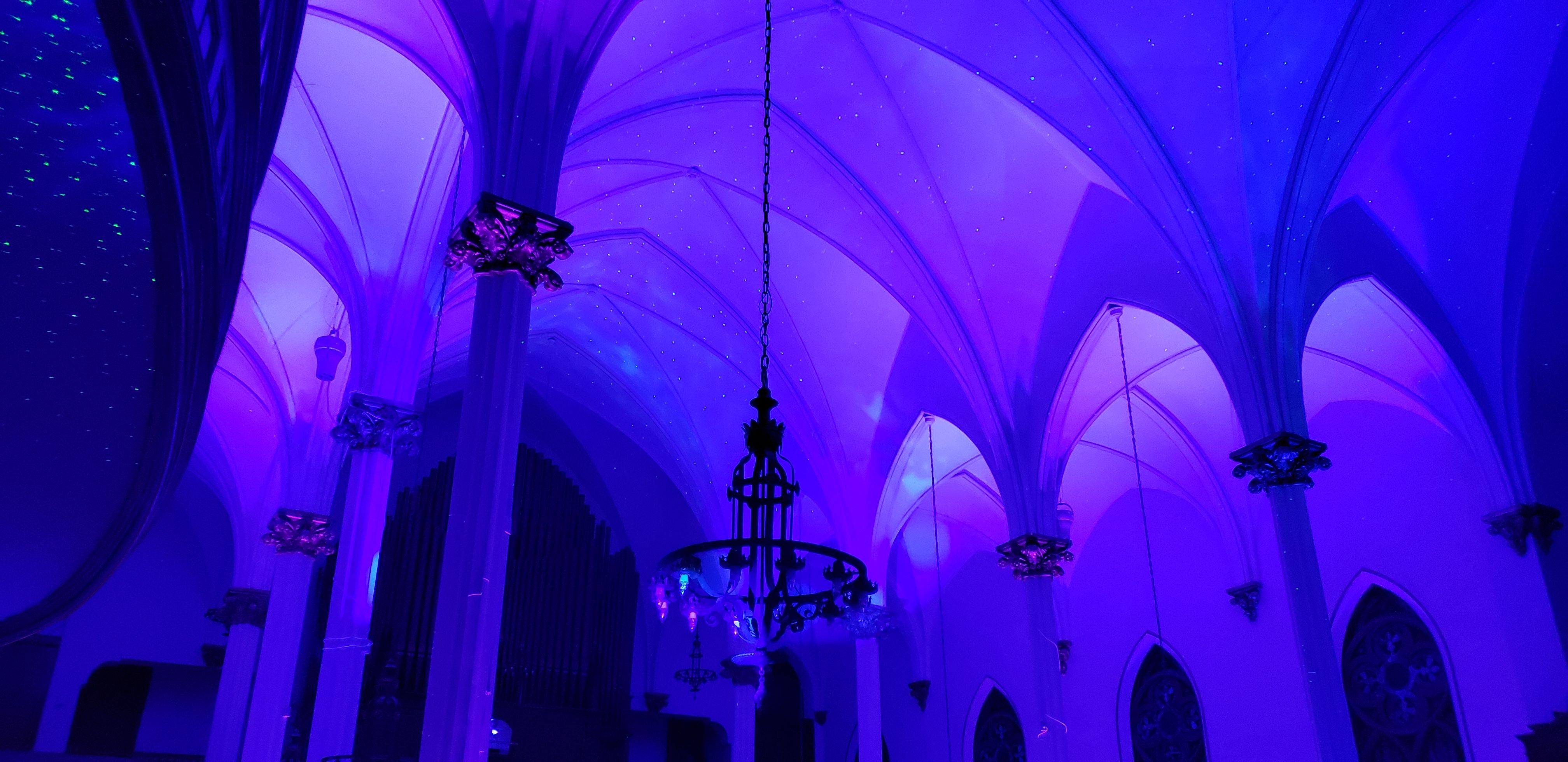 Wedding lighting at Sacred Heart with blue and purple up lighting. Stars and Northern Lights dancing on the ceiling.