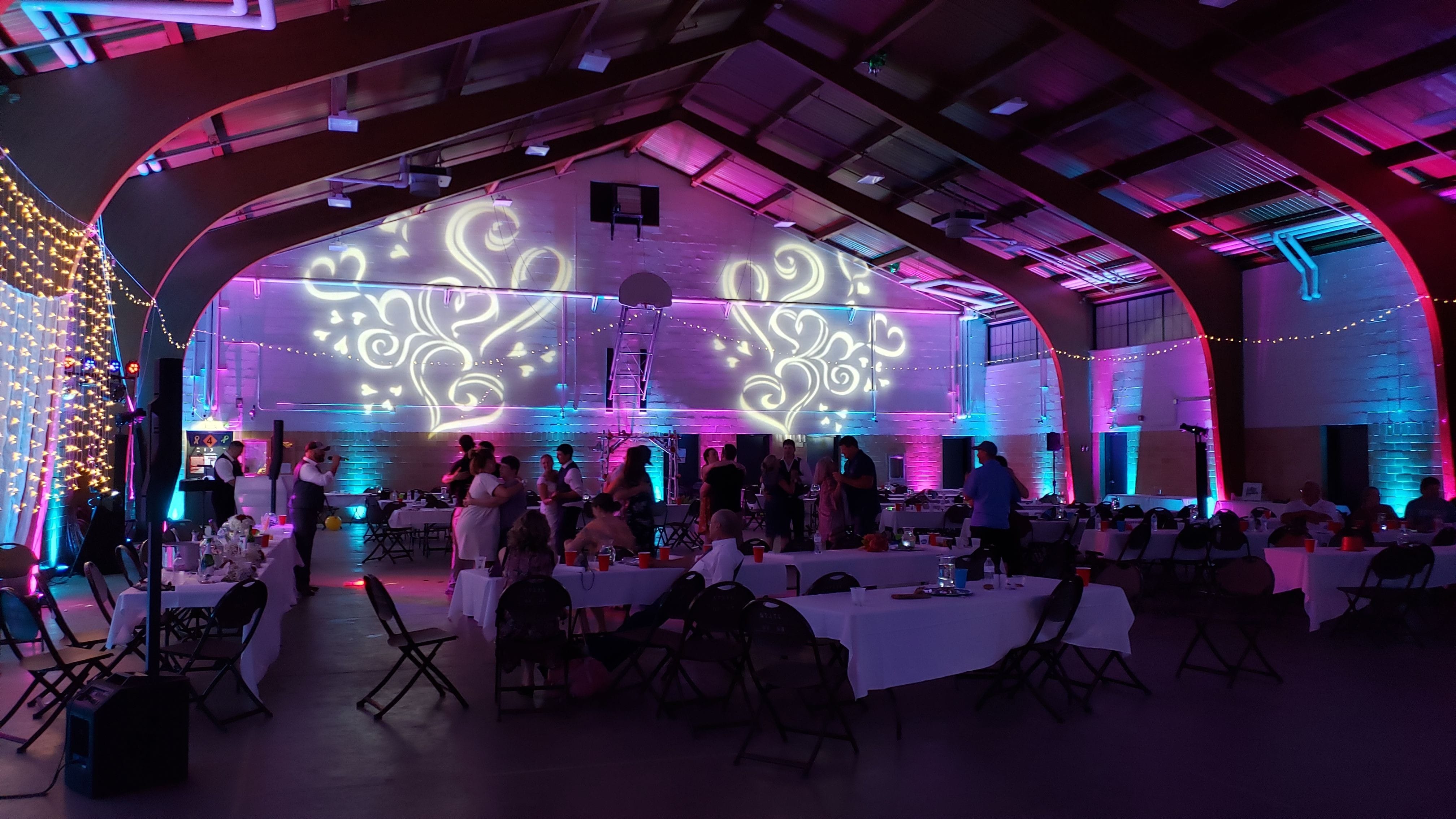 Wedding lighting at the Cloquet Armory by Duluth Event Lighting. Up lighting in blue, teal and magenta with fun heart gobos on the walls.